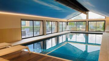 Una piscina cubierta, tumbonas