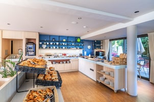 A modern kitchen with a breakfast buffet, wooden cabinets, and a view of the outdoors.