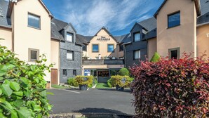 A hotel with a central entrance, multiple windows, and a signboard. - Antares & Spa Honfleur (La Riviere-Saint-Sauveur)