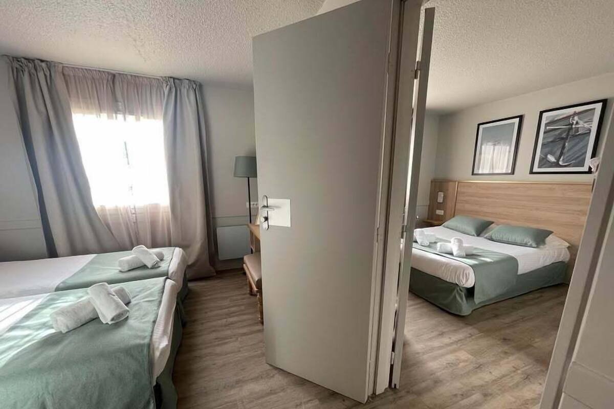 Ein Hotelzimmer mit zwei Betten, einem Schreibtisch und einem Sessel.