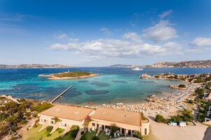 Un hotel frente al mar con playa, muelle y vista al océano.