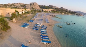 A beach with rows of sun loungers and a clear view of the sea. - Santo Stefano Resort & Spa (La Maddalena)
