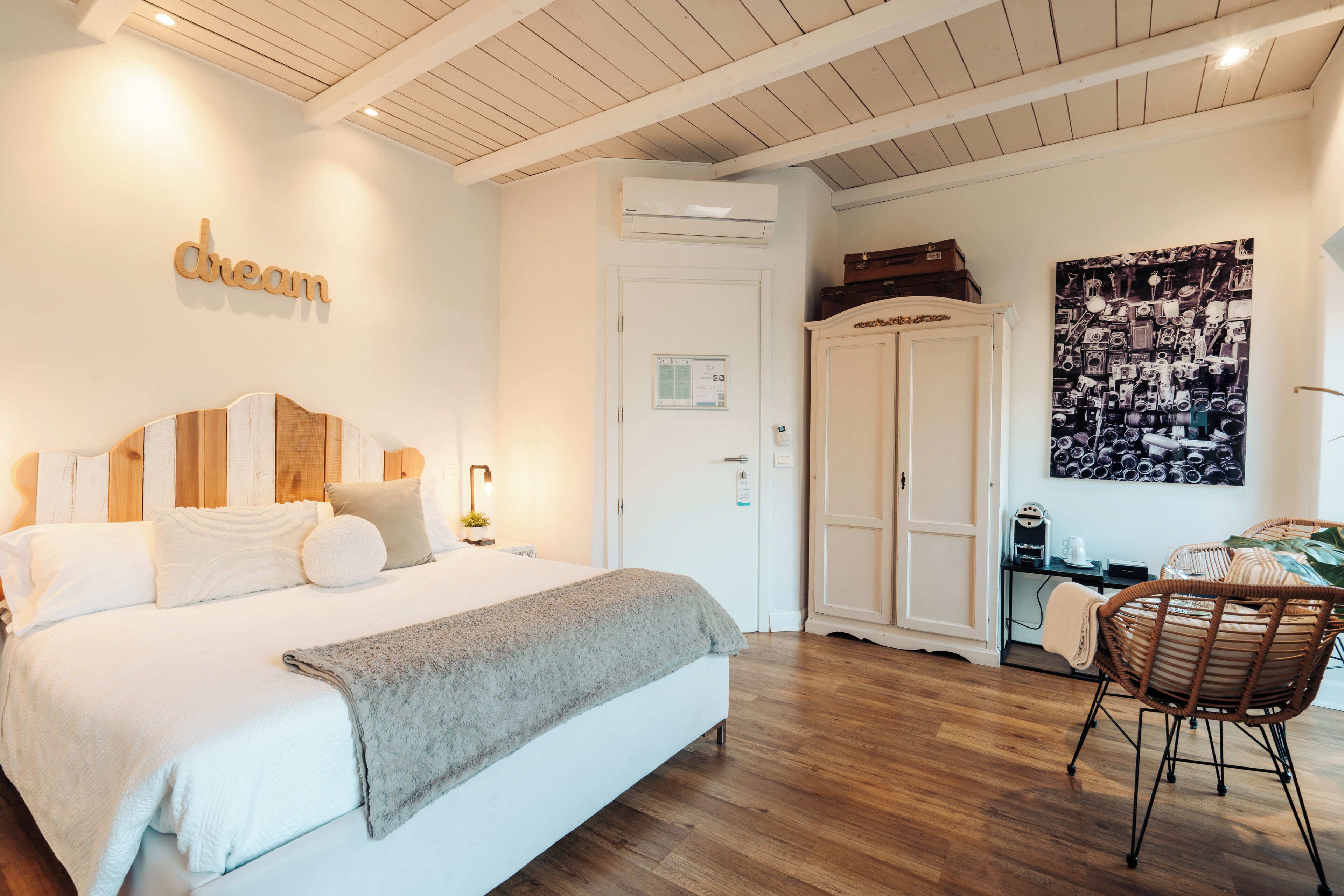 A bedroom with a bed, a wardrobe, a desk, and a chair.
