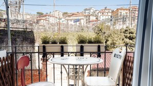 Un balcón con una mesa redonda y dos sillas, una de ellas con la etiqueta "BISTRO".