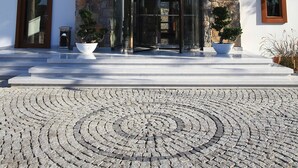 A modern building with a stone facade, a glass entrance, and a clear sky. - Saraya Bodrum Hotel (Bodrum)