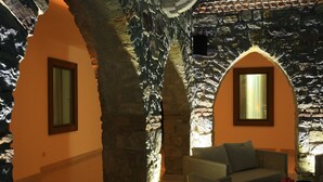 A cozy interior with stone walls, a cushioned seating area, and framed windows. - Saraya Bodrum Hotel (Bodrum)