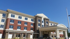 A multi-story building with a mix of brick and stone facades, large windows, and a covered entrance area. - Holiday Inn Express & Suites Lexington Park-California by IHG (California)