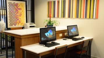A reception area with two computer workstations, a printer, and a decorative wall piece.