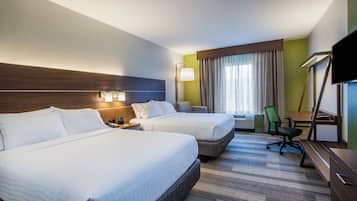 Habitación de hotel con dos camas, un escritorio, una silla, un televisor de pantalla plana y una ventana con cortinas.