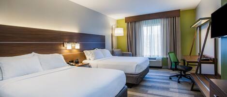 A hotel room with two beds, a desk, a chair, a TV, and a window with curtains.
