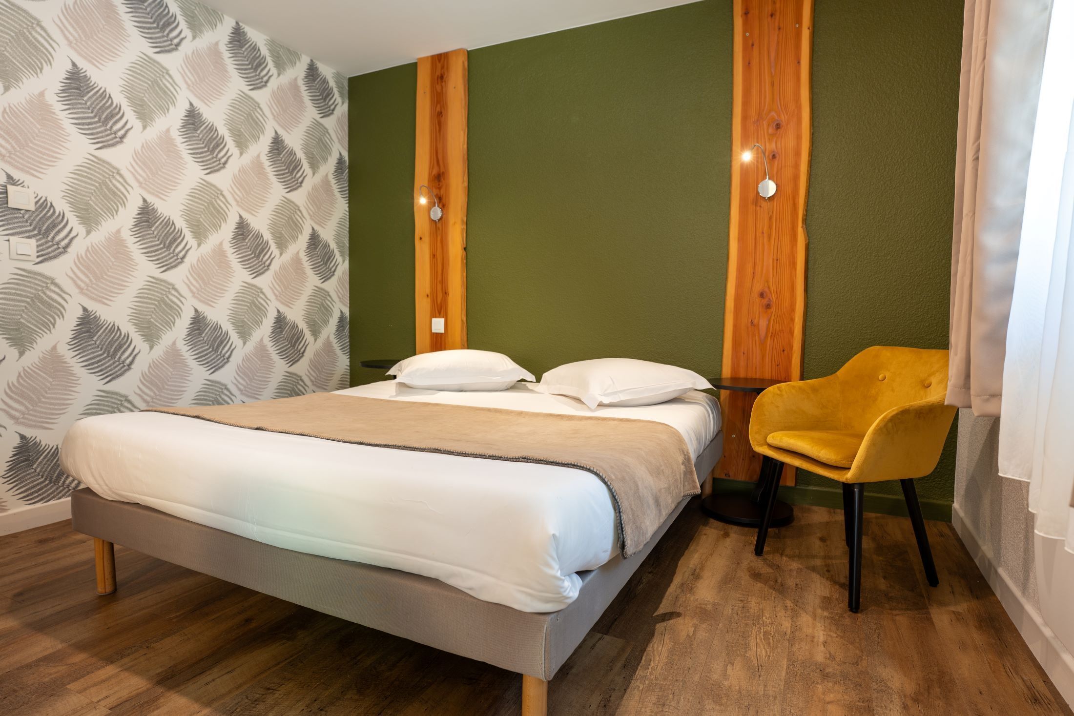 Ein Schlafzimmer mit einem Bett, einem gelben Sessel und einer Wand im Holzdesign.