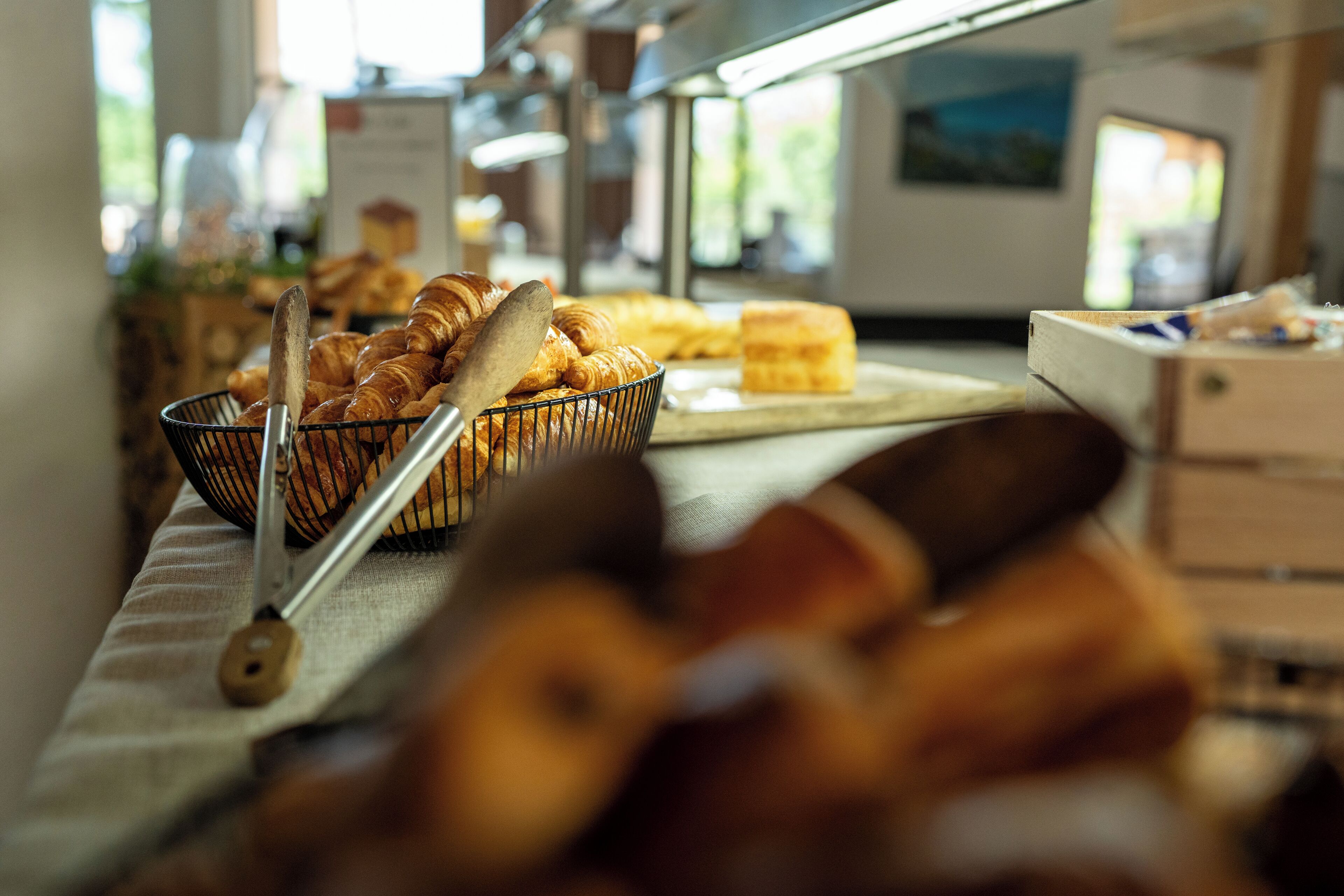 Un buffet proposant une variété de produits de boulangerie, notamment des croissants et des petits pains, disposés sur une table.