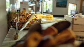 Un buffet proposant une variété de produits de boulangerie, notamment des croissants et des petits pains, disposés sur une table.