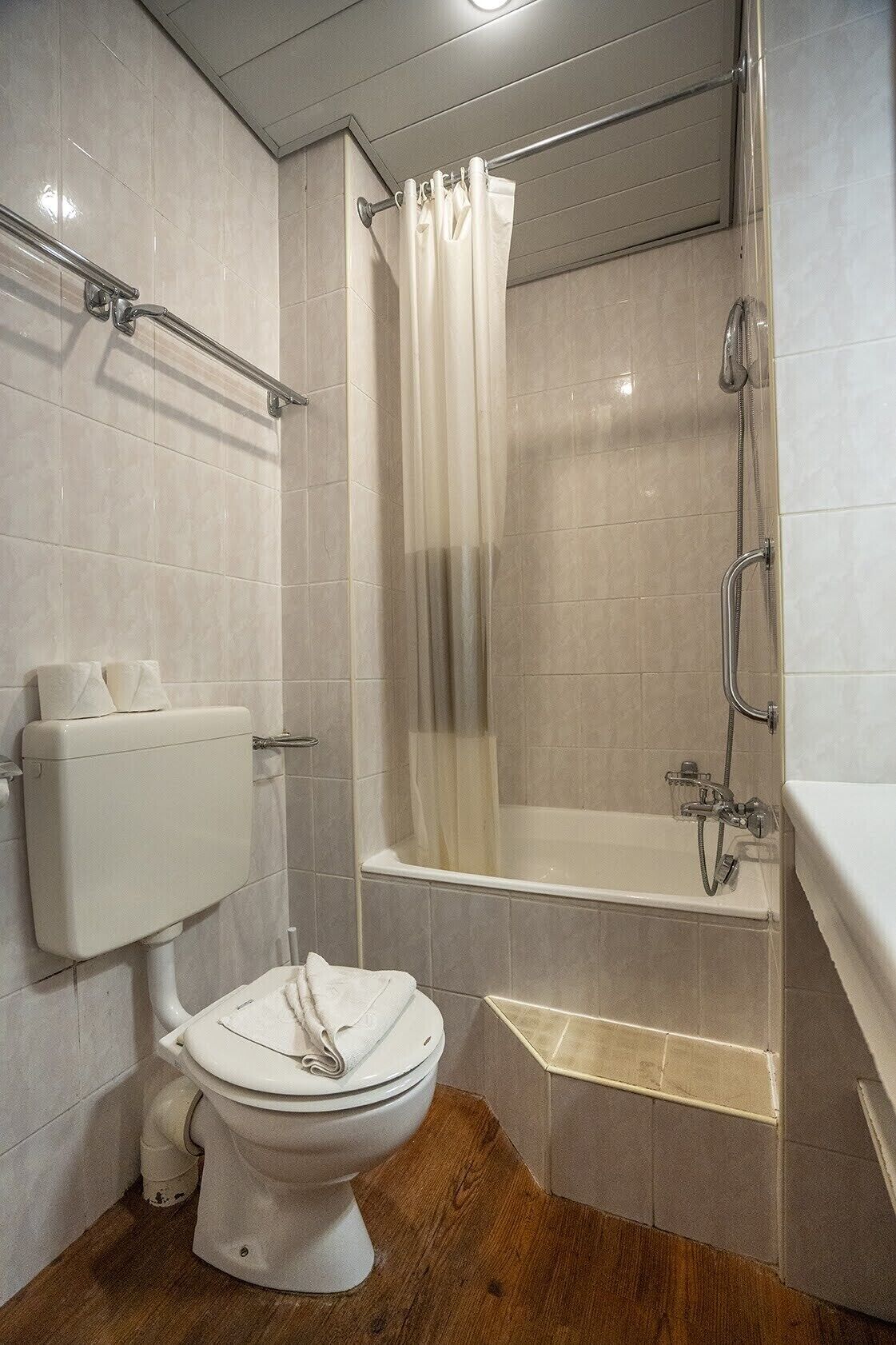 Un baño con inodoro, ducha con cortina y bañera.