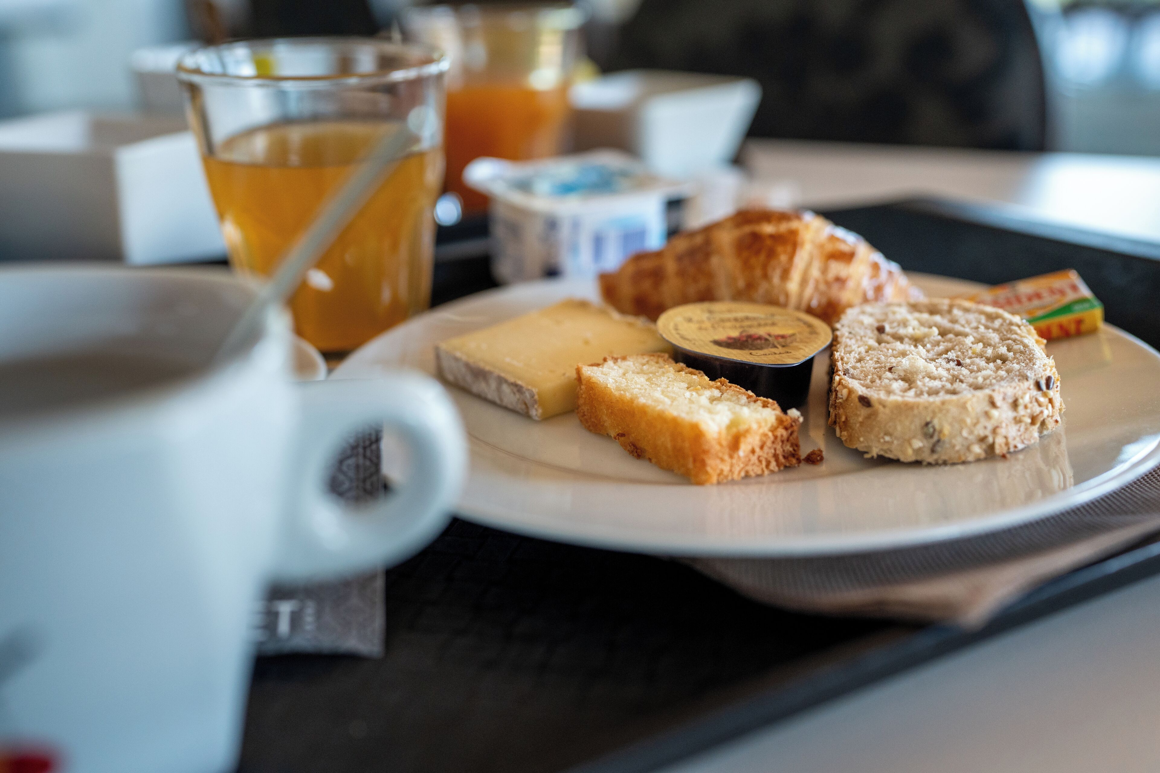 A breakfast plate with cheese, bread, and jam.