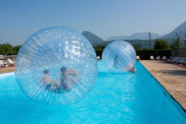 Piscine extérieure en saison, parasols, chaises longues
