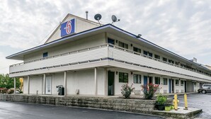 Un motel avec un toit plat, des antennes paraboliques et une enseigne indiquant qu’il s’agit du numéro 6.