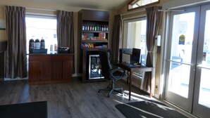 Ein Zimmer mit Küchenzeile, Kühlschrank, Computertisch und Stuhl.