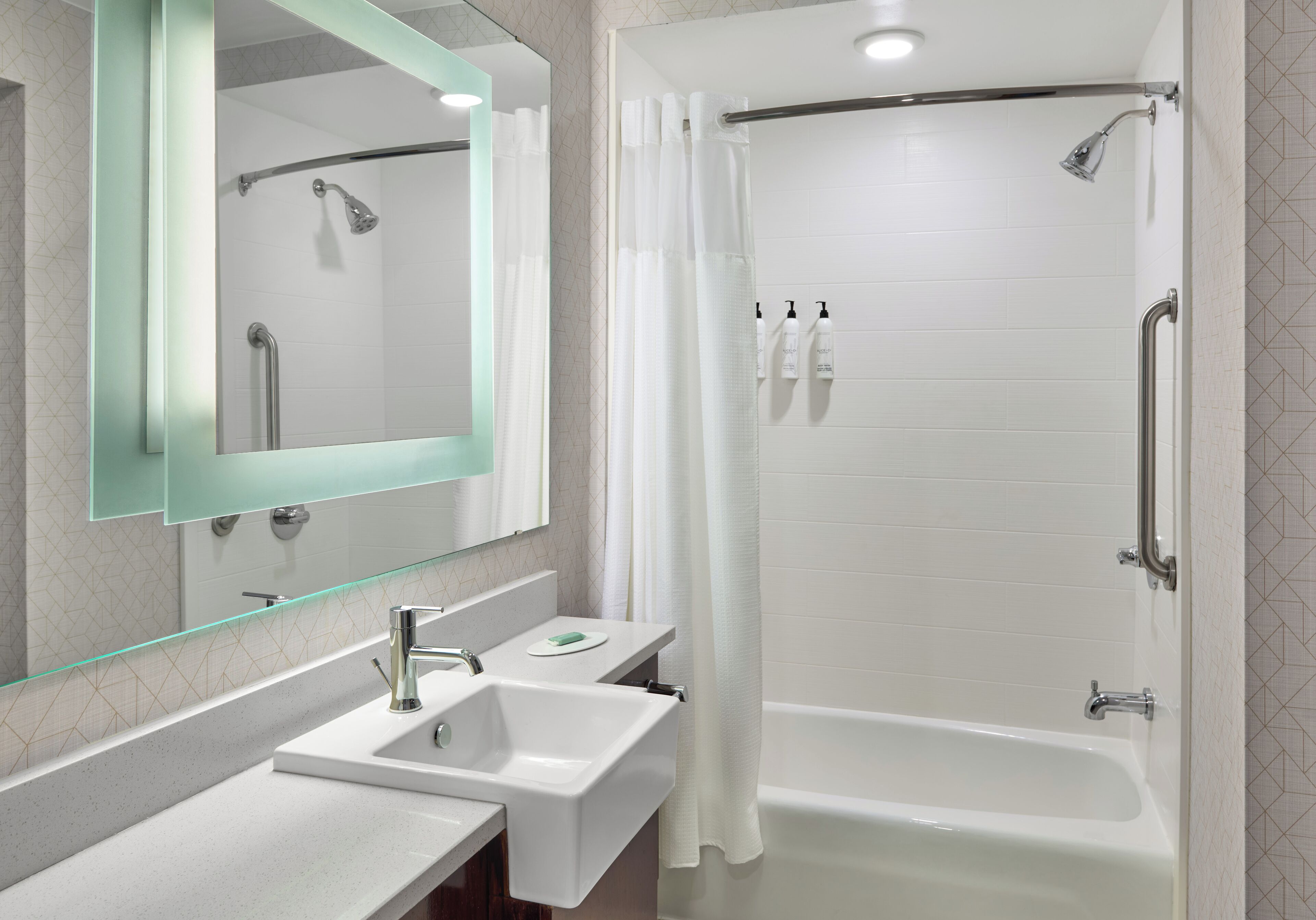 Une salle de bain moderne avec une douche à parois de verre, un lavabo blanc et une baignoire.