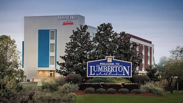 Un hotel moderno con un cartel que da la bienvenida a visitantes en Lumberton, Carolina del Norte.
