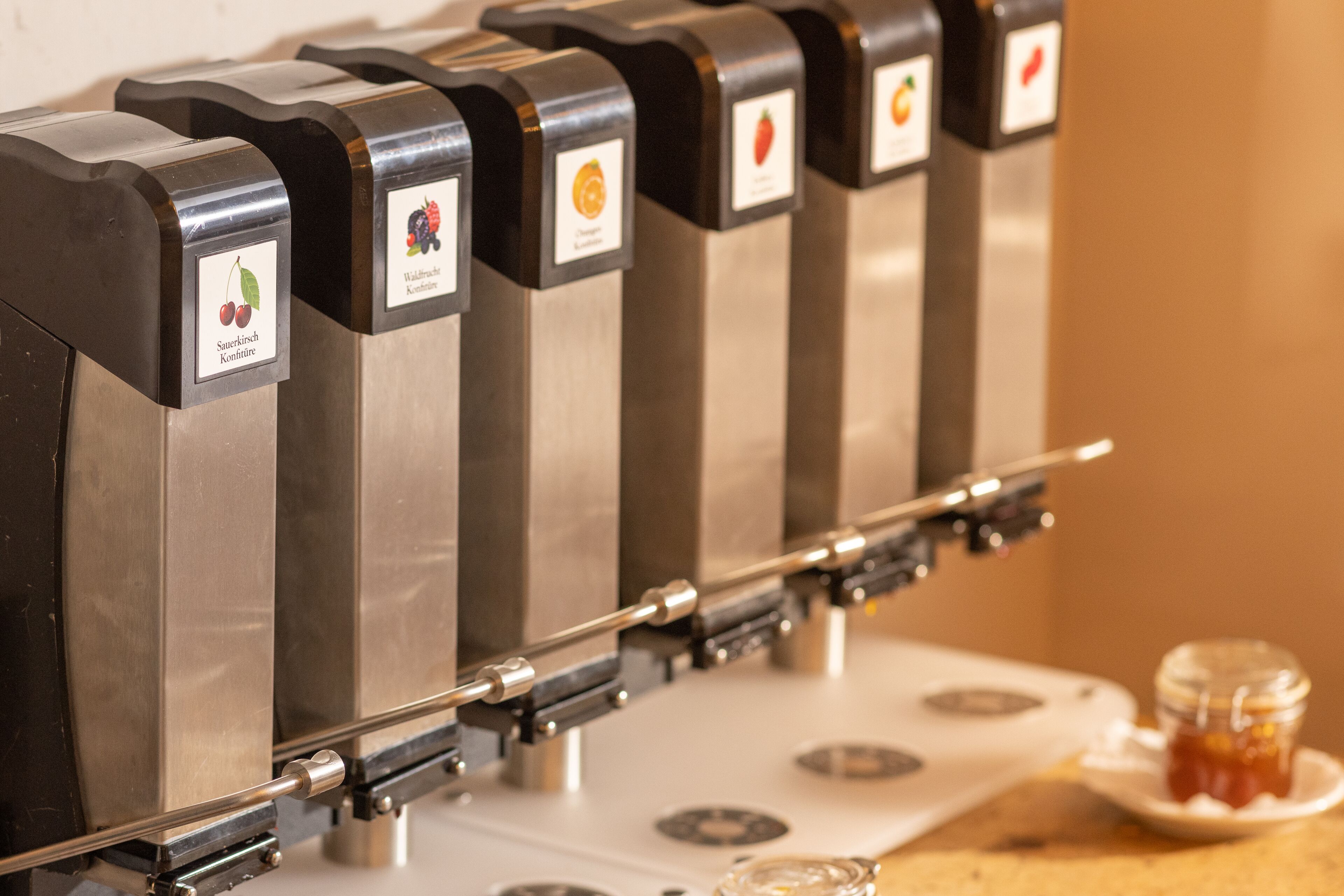 A row of beverage dispensers with labels indicating different types of drinks.
