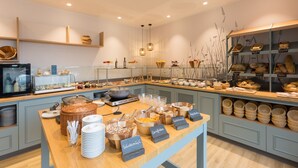 A buffet area with various food items and serving utensils. - Koopmanns Hotel und Lädchen (Göhren)