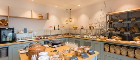 Un área de bufé con diferentes alimentos y utensilios para servir.