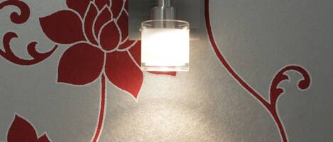 A wall with a floral pattern and a light fixture.