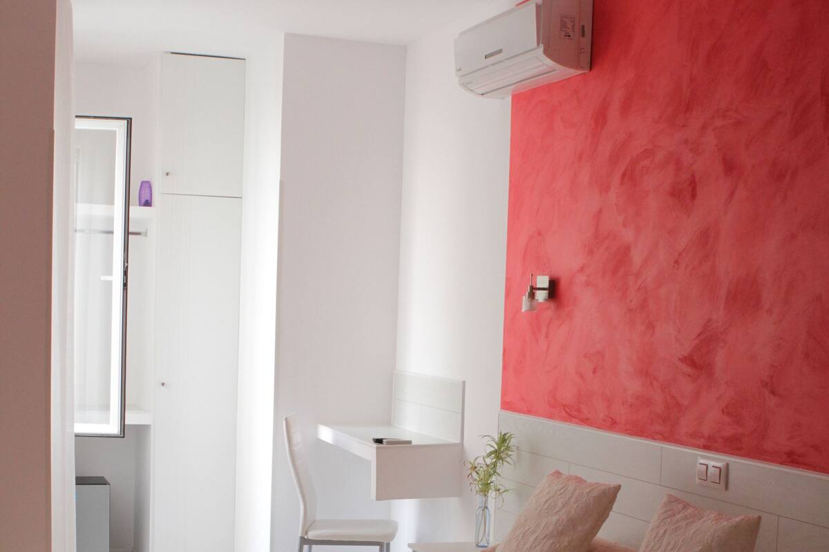 Un dormitorio con cama, escritorio y silla.