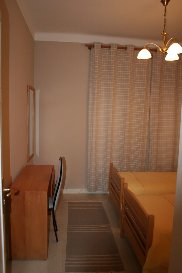 A bedroom with a wooden desk, a bed, a chair, and a window with curtains. - Villa Ambre (La Marsa)