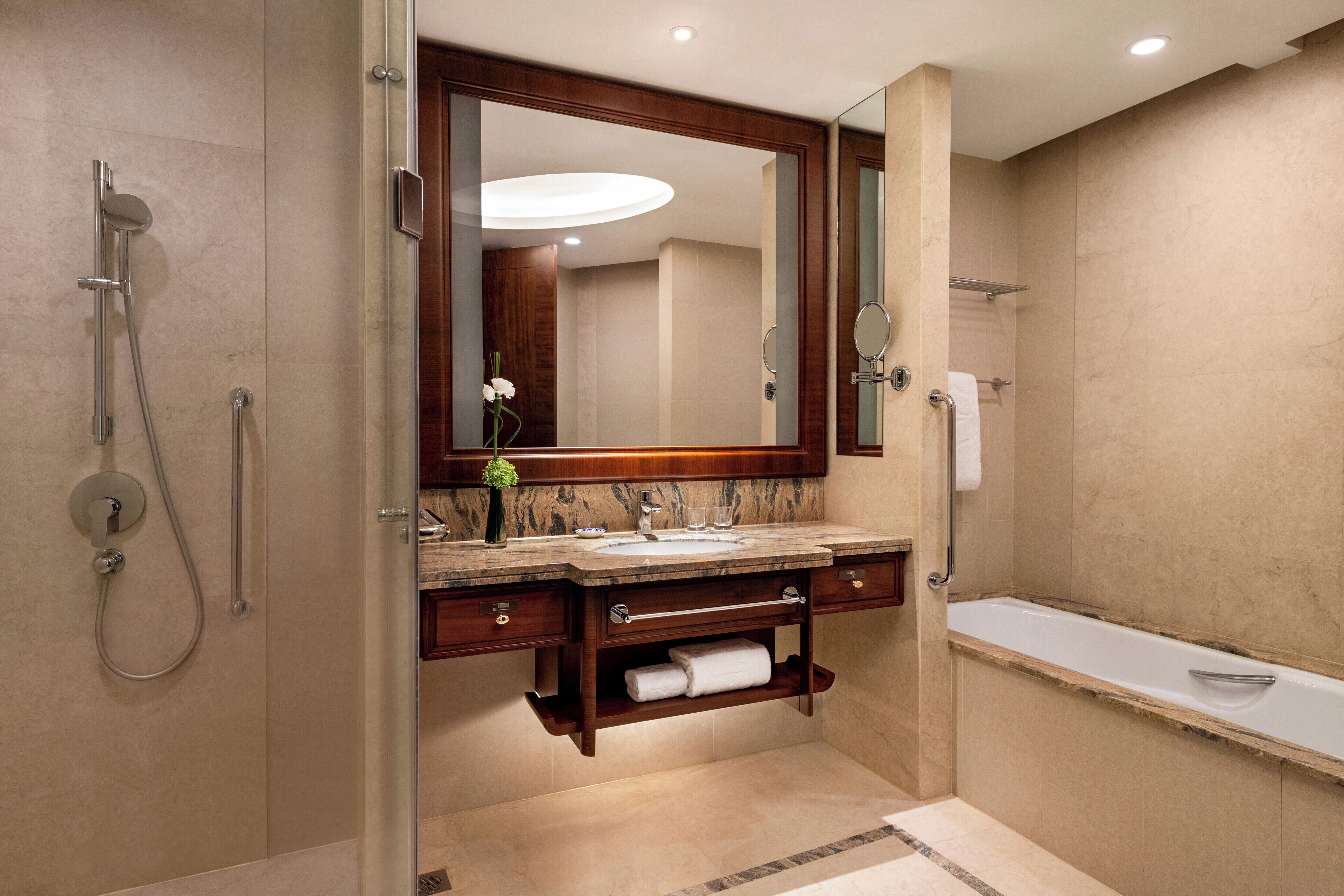 A modern bathroom with a large mirror, a sink, a shower, and a bathtub.