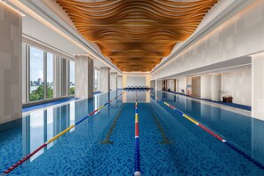 A swimming pool with clear lanes, a wooden ceiling design, and large windows offering a view of the city. - Shangri-La Nanchang (Nanchang)
