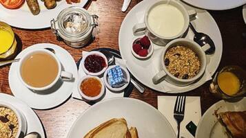 Una mesa de desayuno con diferentes platos, incluyendo tostadas, huevos, salchichas y una variedad de acompañamientos.