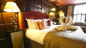 A hotel room with a large bed, two bedside lamps, a nightstand, and a window with curtains. - The Chapter House (Salisbury)