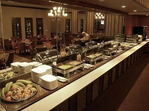 Un buffet proposant une variété de plats et d'ustensiles.