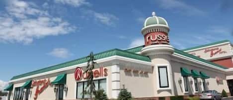 A building with a green roof and a dome-shaped structure on the right side.