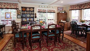 Un comedor con una mesa y sillas de madera, rodeado por un tapete estampado.