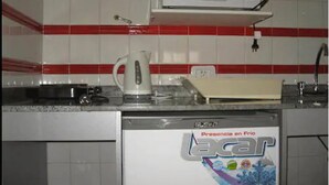 Une cuisine équipée d’un four à micro-ondes, d’une bouilloire et d’une boîte étiquetée « Lacer ».