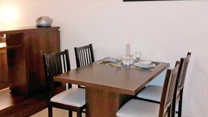 Un coin repas comprenant une table rectangulaire, six chaises et un buffet.