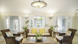 A spacious living room with a large sofa, two armchairs, a coffee table, and a decorative vase. - Green Monkey Villa (Holetown)