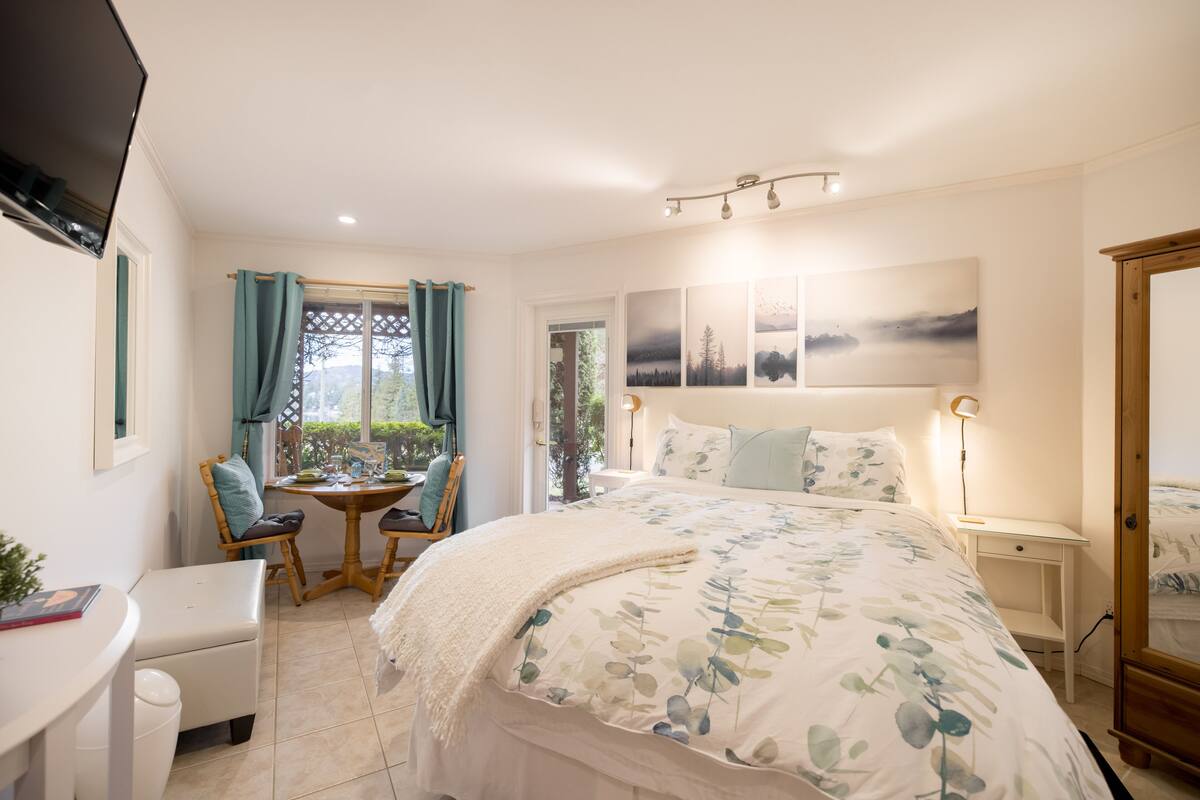Un dormitorio con una cama grande, un escritorio, una silla y una ventana con cortinas.