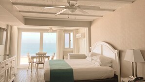 A bedroom with a bed, a desk, and a chair near a window with a view. - Surf Club Oceanfront Hotel (Dewey Beach)