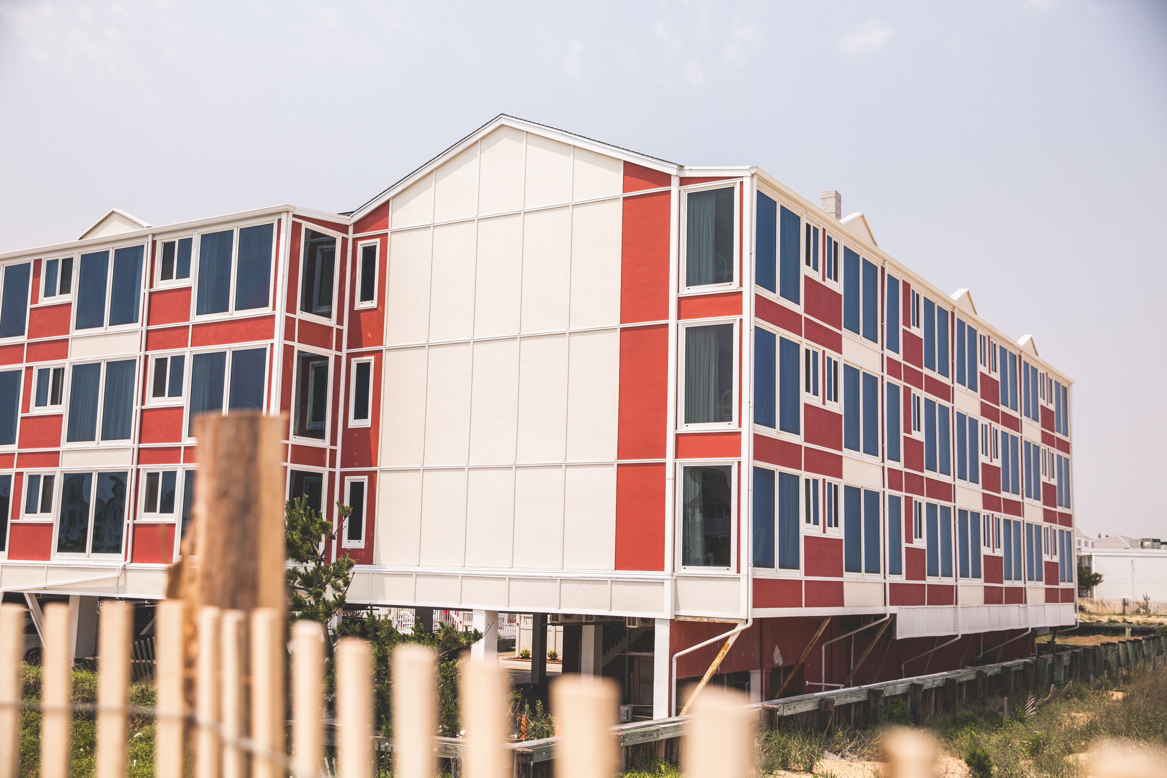 A multi-story building with a distinctive red and white facade, large windows, and a flat roof.