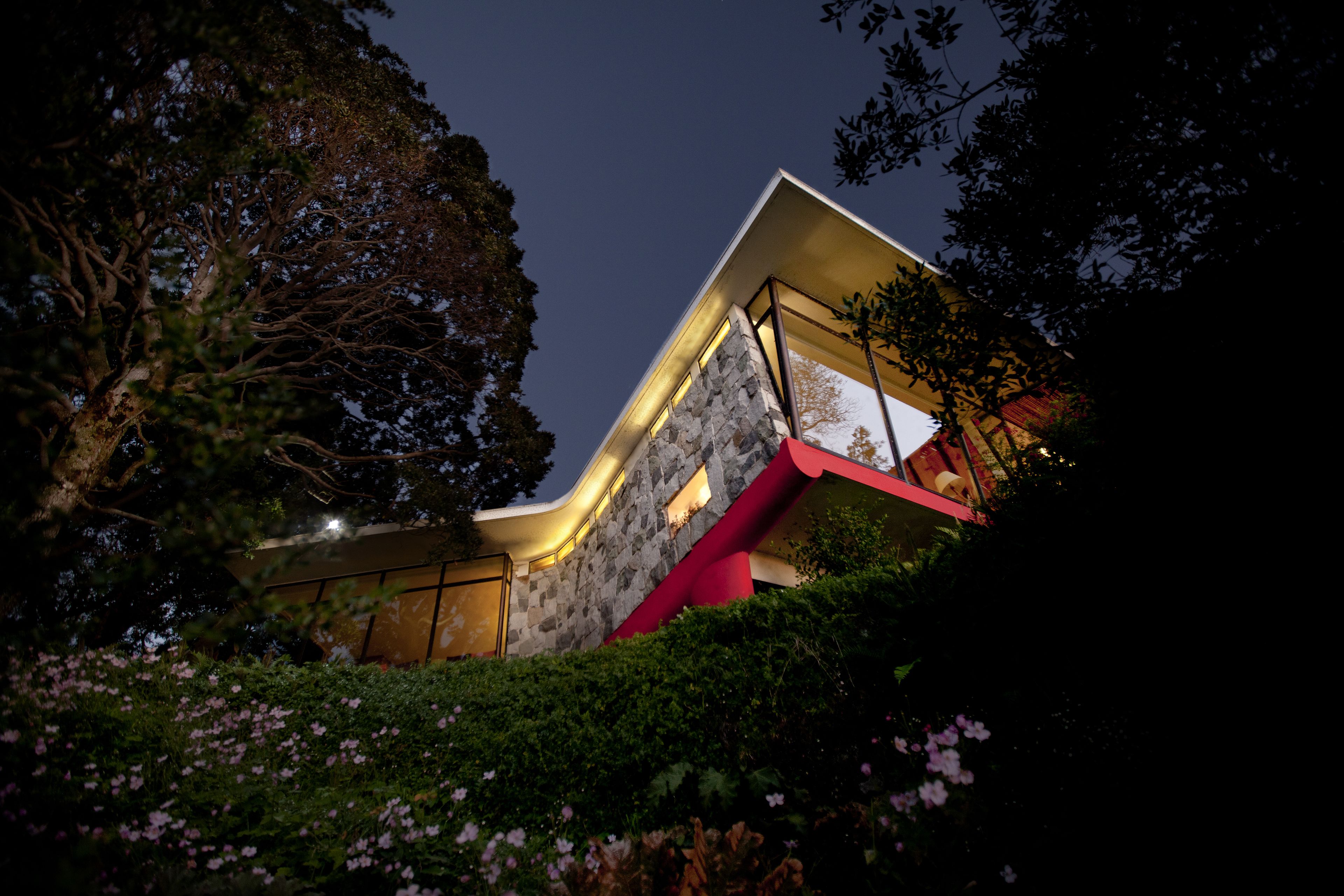 Un edifici modern amb façana de pedra i escala vermella.