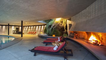 Relax by the pool and enjoy the warmth of the fireplace in this inviting indoor space.