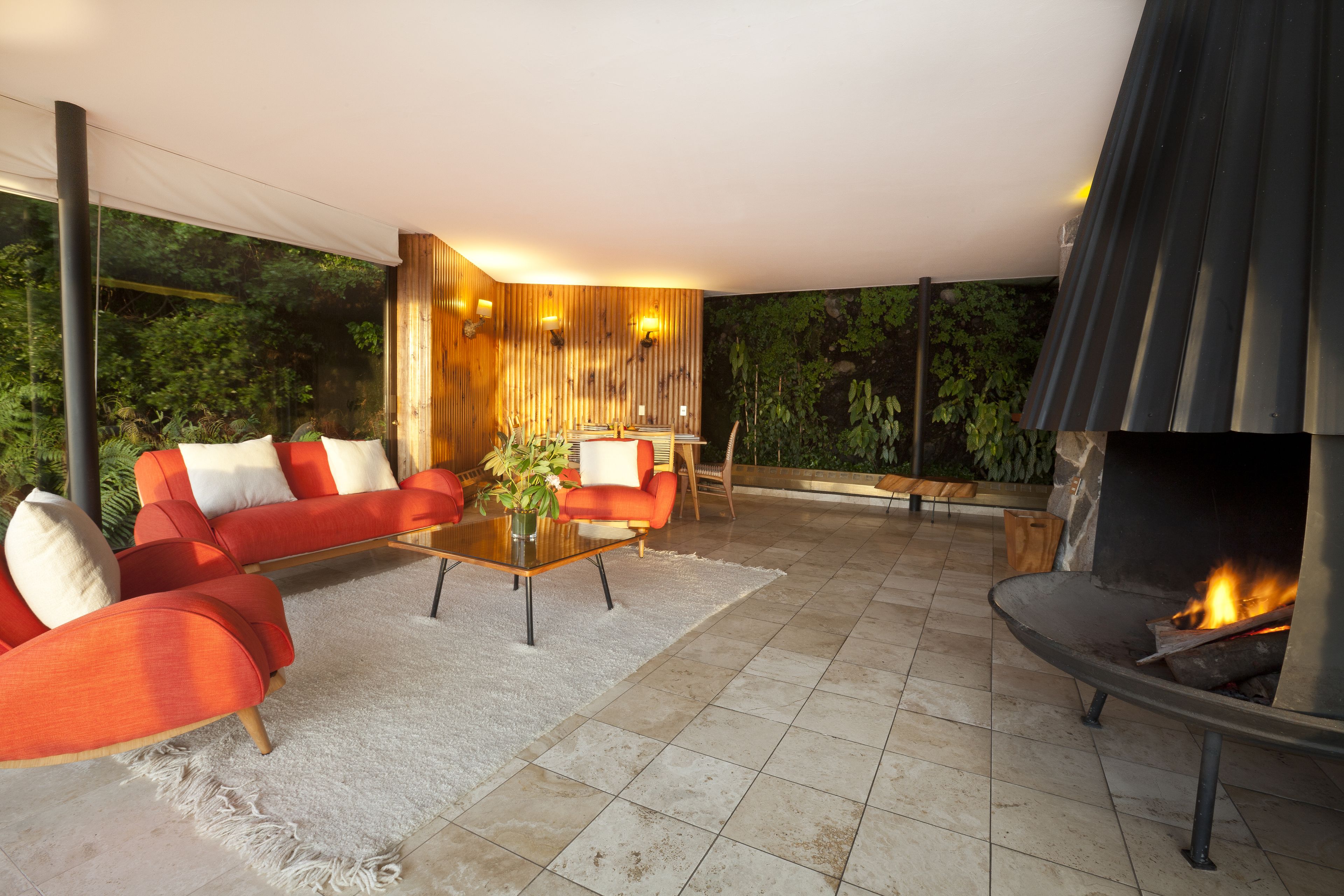 A modern outdoor living area with a sofa set, a coffee table, and a fireplace.