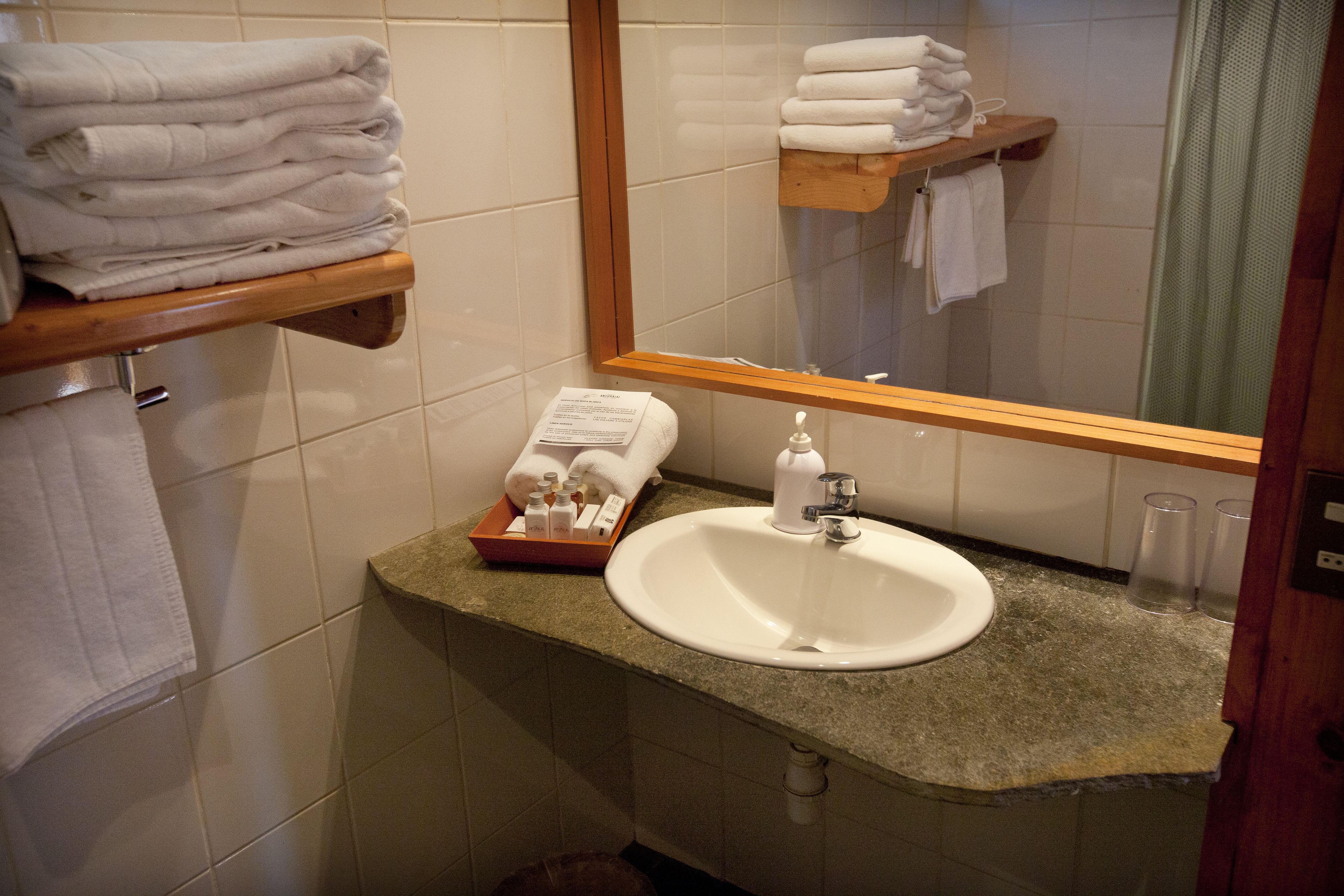 A bathroom with a sink, mirror, and towel rack.