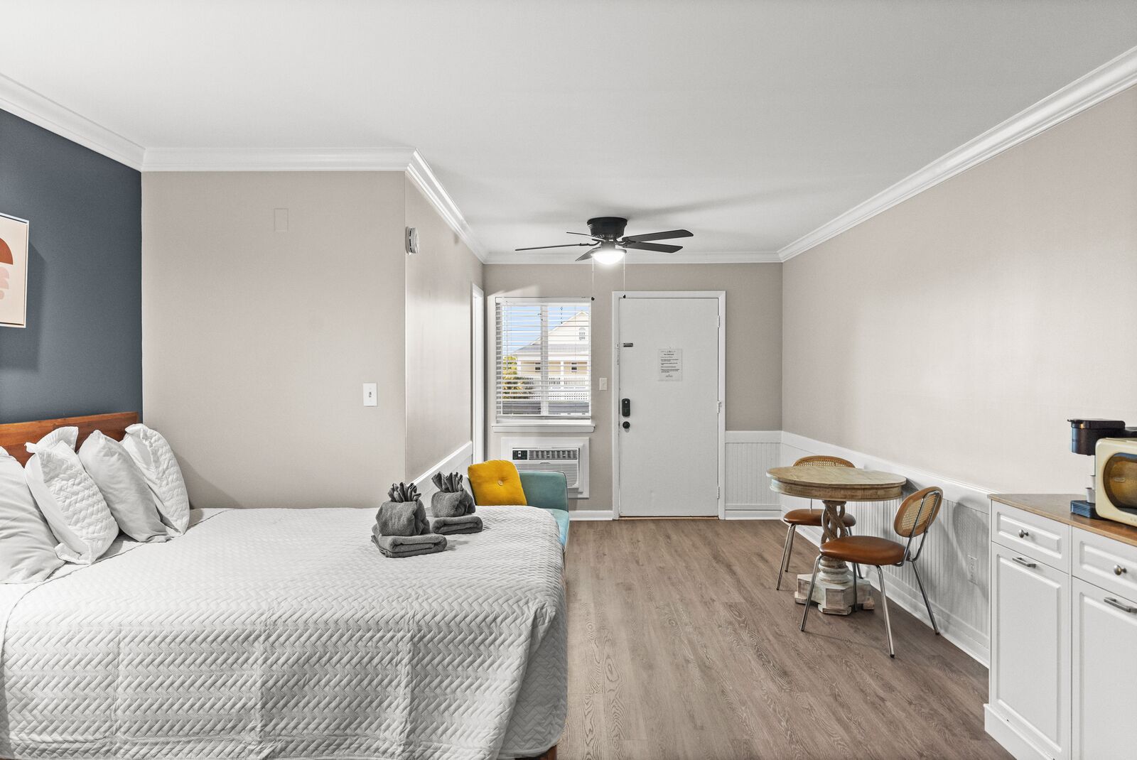 A bedroom with a bed, bedside table, and a window with blinds.