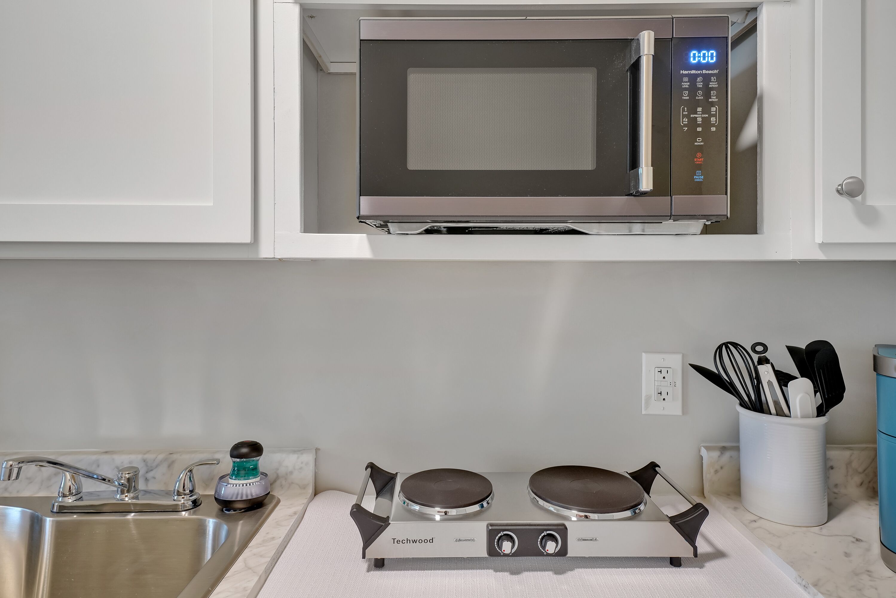 A kitchen with a microwave, a stove, and a sink.
