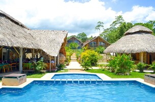 Una piscina al aire libre, sillones reclinables de piscina